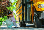 Girl hugging mom near school bus
